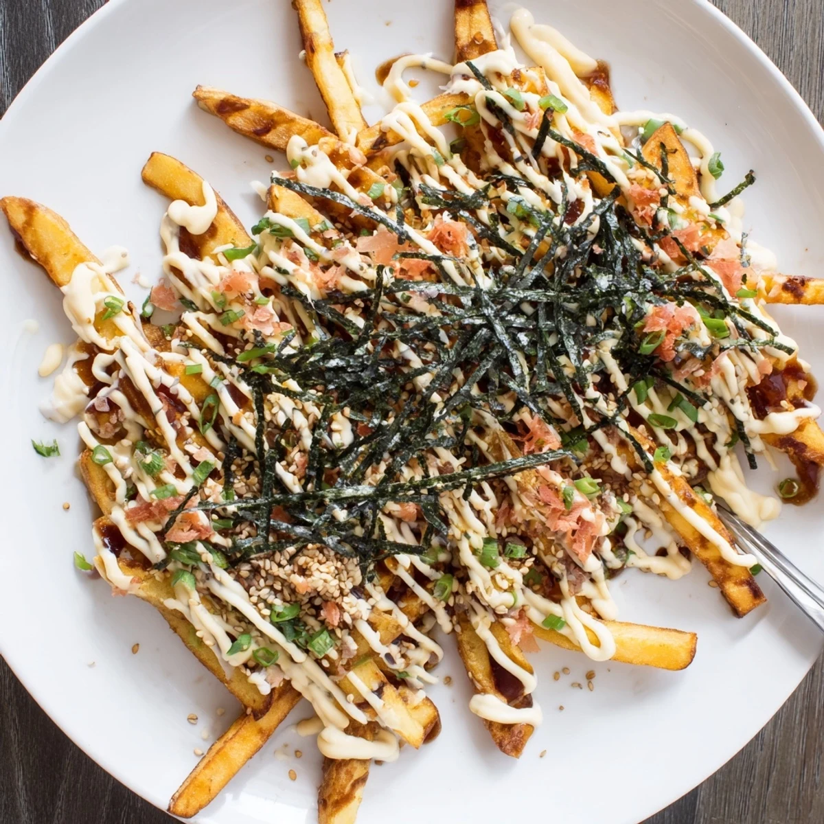 Crispy Japanese Okonomiyaki fries topped with tangy sauce and fresh green onions.  
