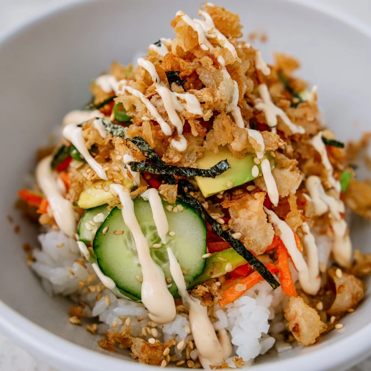 Crispy tempura bits atop a Crunch Roll Sushi Bowl with colorful vegetables.  
