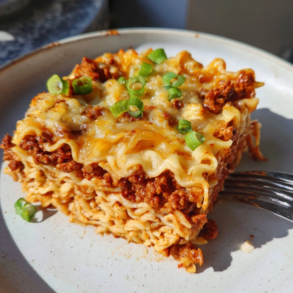 Spicy Ramen Lasagna layered with creamy cheese and spicy ground pork, perfect for dinner.  