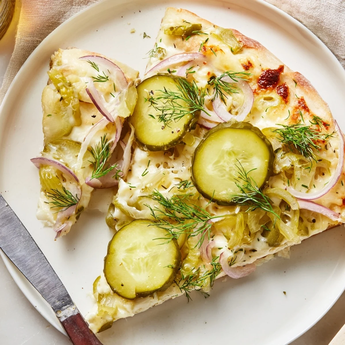 Tangy Pickle Pizza topped with creamy sauce, mozzarella, and crunchy dill pickles.  