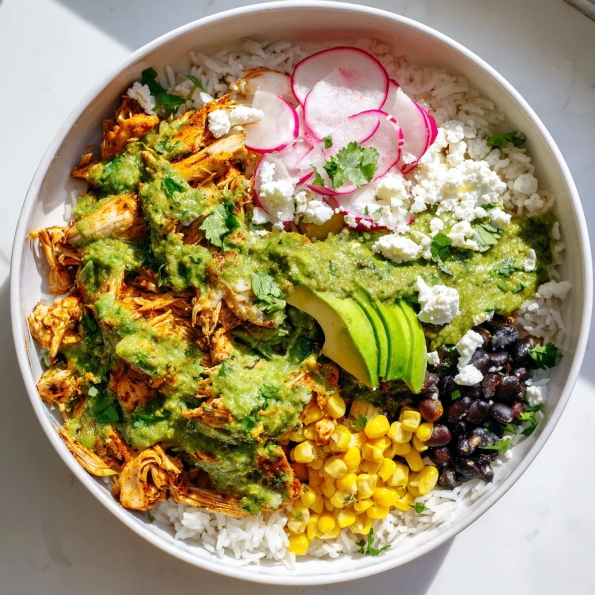 Hearty Green Enchiladas Rice Bowl featuring chicken in green sauce, ready to serve with fresh lime wedges.