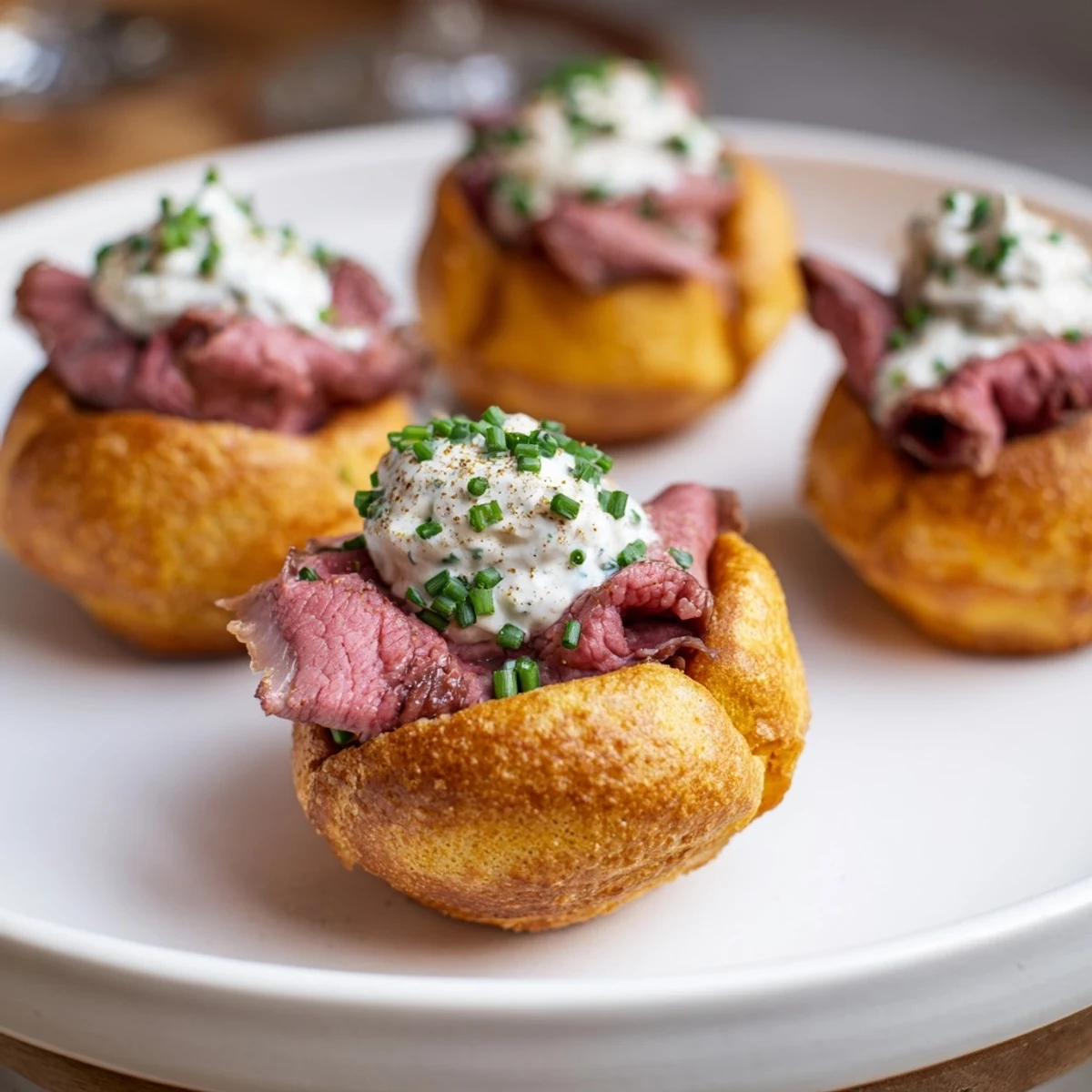 Miniature Yorkshire Pudding Bites, ready to enjoy: a holiday appetizer with roast beef and a creamy filling.