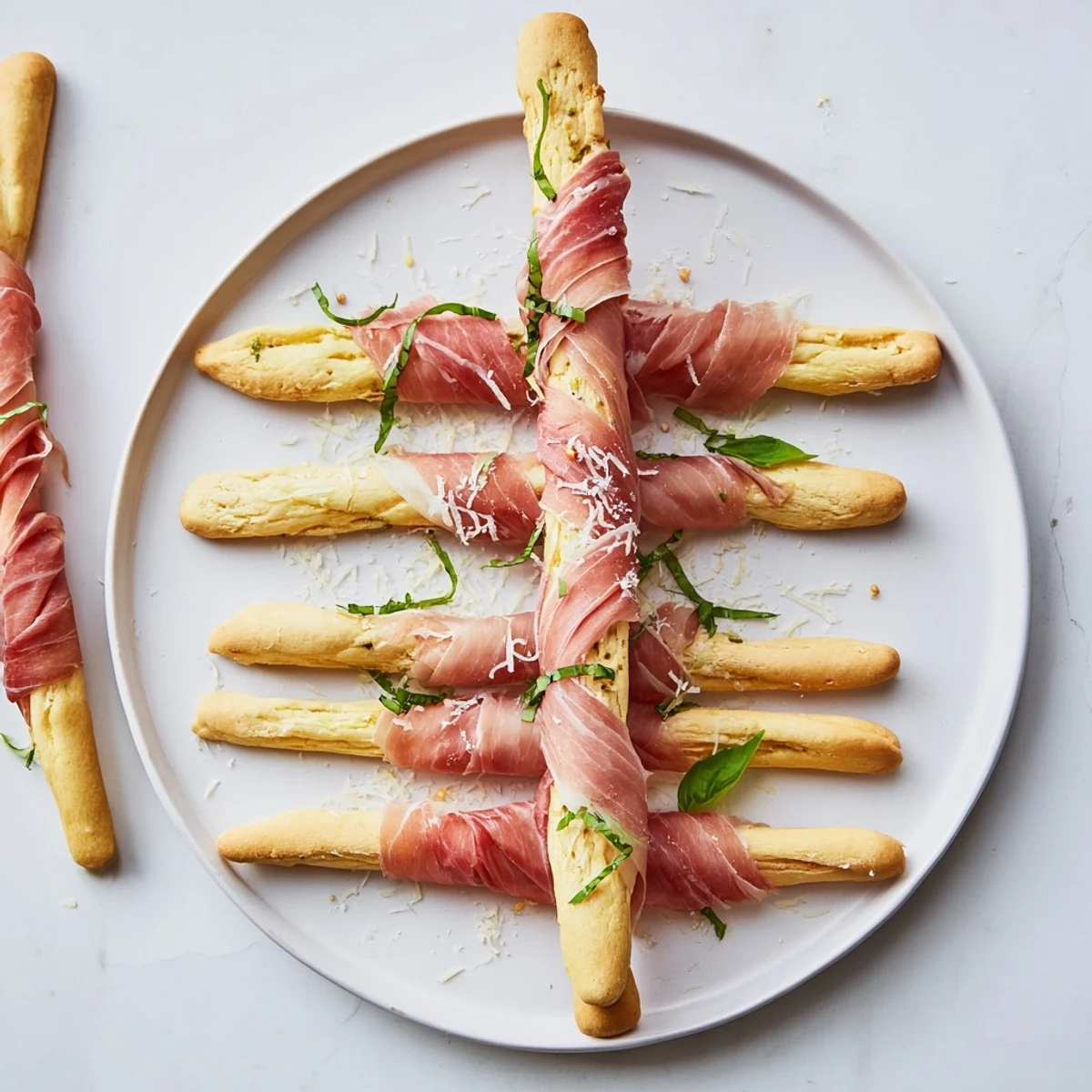Savory prosciutto drapes between breadstick towers, forming a delicious "Golden Gate" appetizer, ready to eat.
