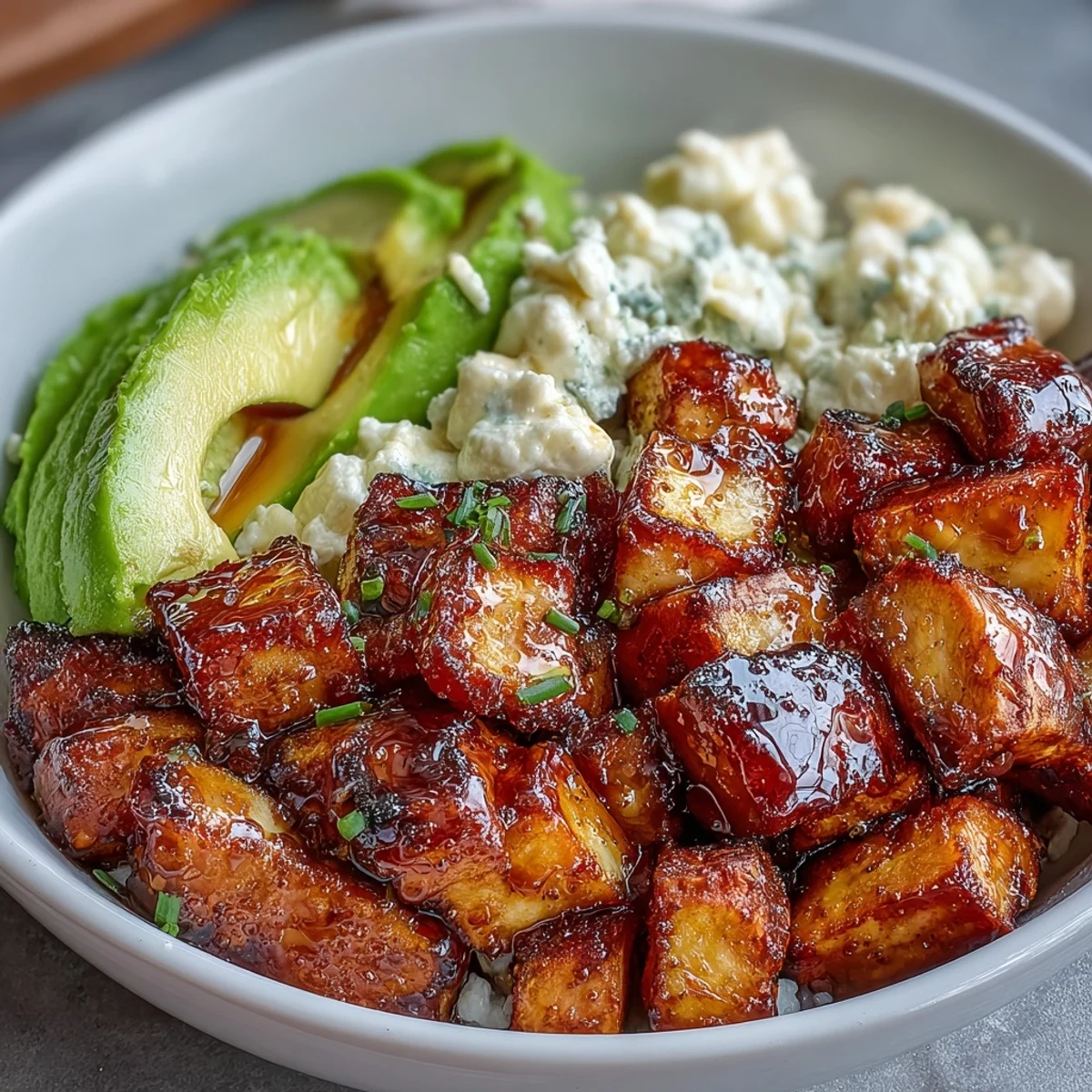 Golden-brown sweet potatoes topped with cottage cheese and avocado for a vibrant Hot Honey Sweet Potato Bowl.