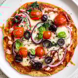 Freshly baked crispy tortilla pizza featuring vibrant toppings and oozing cheese, a quick dinner idea.