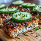 Delicious crispy rice sardine toasts showcasing vibrant garnishes on a platter.
