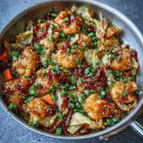 Vibrant skillet of sautéed cabbage and dumplings topped with spicy honey drizzle.