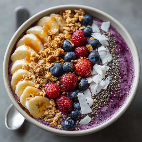 Protein-Packed Berry Smoothie Bowl with creamy banana blend, topped with vibrant fresh berries and granola.