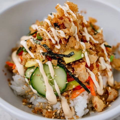 Crispy tempura bits atop a Crunch Roll Sushi Bowl with colorful vegetables.  