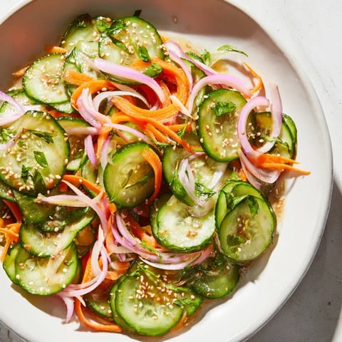 A vibrant cucumber salad remix showcasing fresh vegetables and savory Asian flavors.  