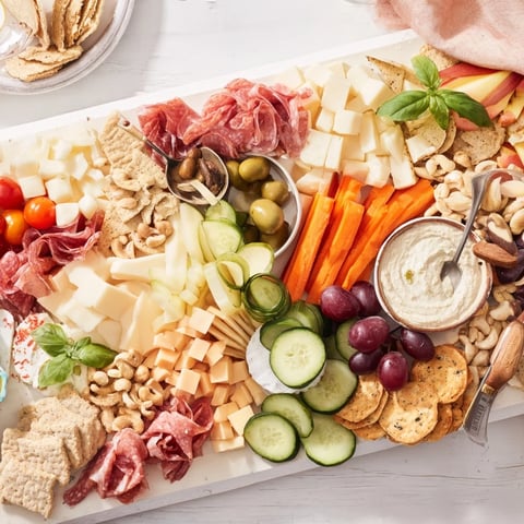 A vibrant Girl Dinner Platter filled with cheeses, fruits, and delicious dips.  