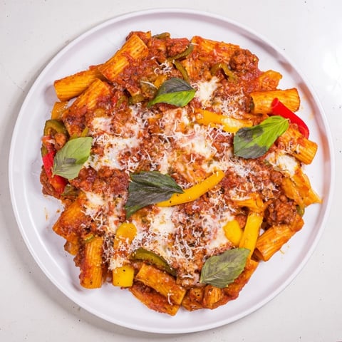 Savory Baked Rigatoni with Sausage & Peppers topped with melted cheese and fresh herbs.  