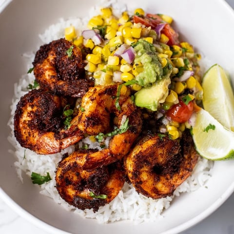 Spicy blackened shrimp bowl glistening with avocado corn salsa, offering a taste of Southwestern flavors.