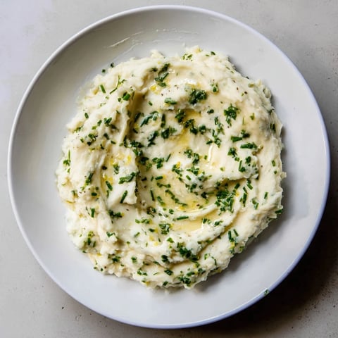 Creamy cauliflower mash with roasted garlic and herbs, a healthy, flavorful side dish.