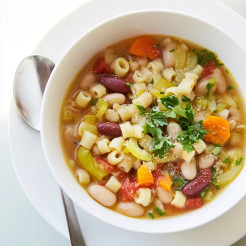 Steaming bowl of Pasta e Fagioli Soup, garnished with fresh parsley and Parmesan cheese, ready to warm you.
