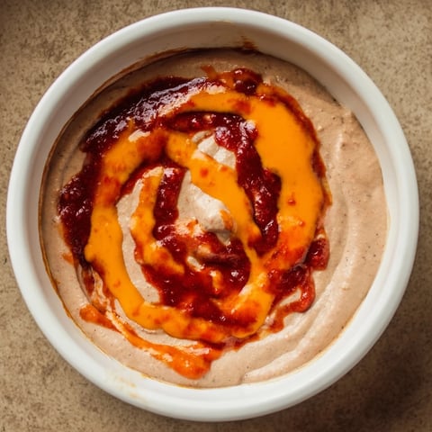 Creamy, homemade spicy black bean dip, ready to serve with crispy tortilla chips at a party.