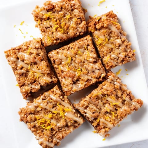 Golden-brown Lemon-Glazed Gingerbread Crumble Bars, glistening with tangy citrus glaze, ready to be enjoyed.