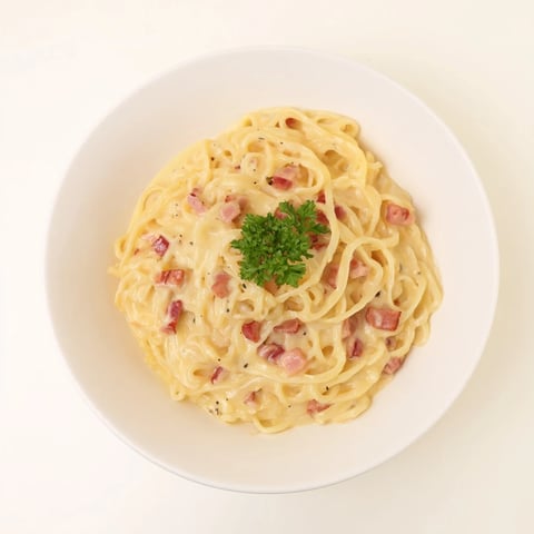 Steaming bowl of Carbonara Ramen Fusion: creamy noodles with crispy bacon, ready to eat.