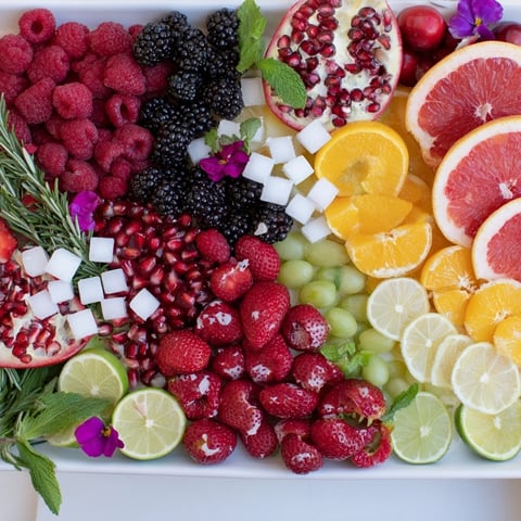 A vibrant Bubbly Bar New Years Eve Garnish Tray with glistening fruits and fresh herbs, perfect for celebration.