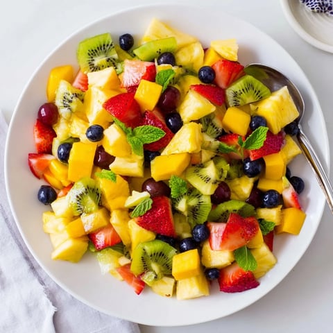 A colorful Tropical Pineapple Fruit Boat brimming with fresh fruit, perfect for a summer dessert.