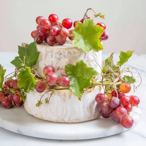 A visually stunning photo of The Rustic Vineyard cheese board, ready to serve with grapes.