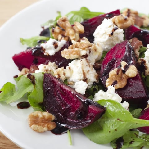 Vibrant beet and goat cheese salad, showcasing sweet roasted beets with creamy cheese and walnuts.