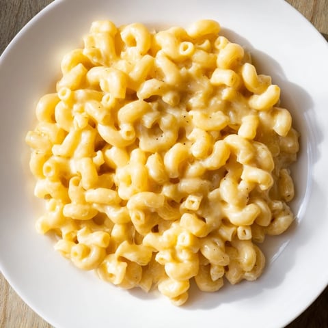 A close-up of creamy, cheesy mac and cheese, a comforting American classic, ready to serve.