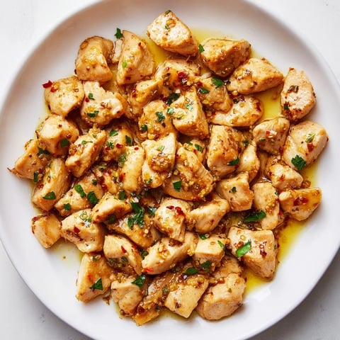 Golden, glistening Garlic Butter Chicken Bites, seared to perfection, ready to serve with parsley.