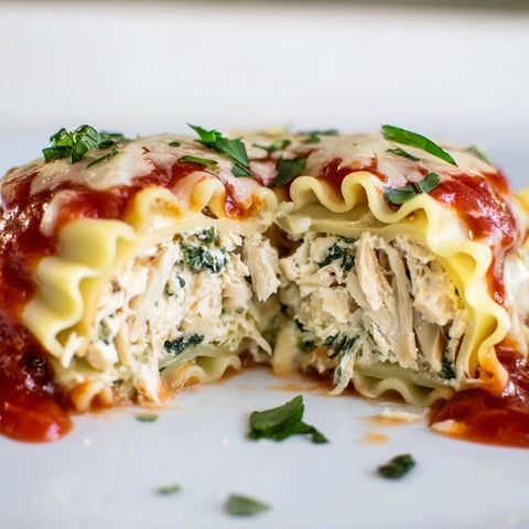 Golden-baked Chicken and Spinach Lasagna Rolls resting in a ceramic dish, garnished with fresh parsley and extra Parmesan.