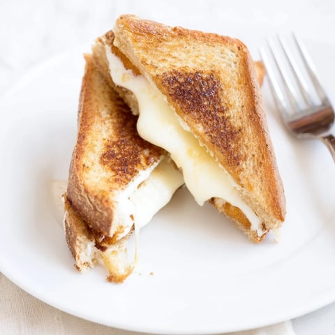 Mozzarella Stick Grilled Cheese sandwich with golden, buttery bread layers and gooey melted cheese.
