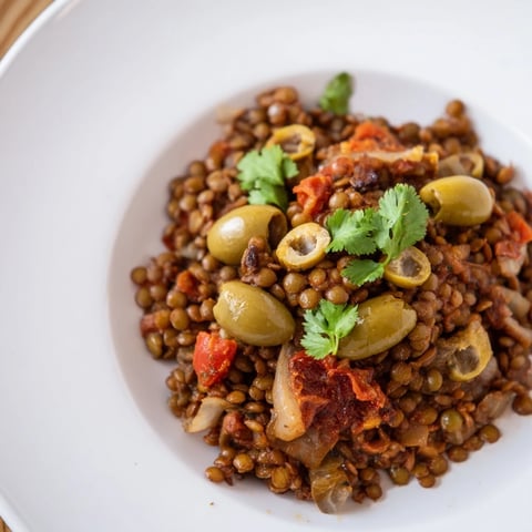 Hearty Cuban-Inspired Lentil Picadillo simmered with briny olives and sweet raisins, served over fluffy white rice.  