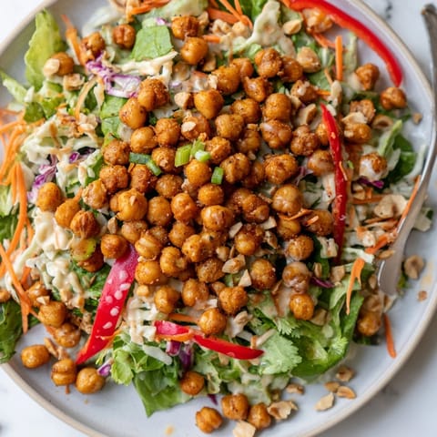 Golden brown roasted chickpeas in a bowl of colorful Thai Peanut Salad.