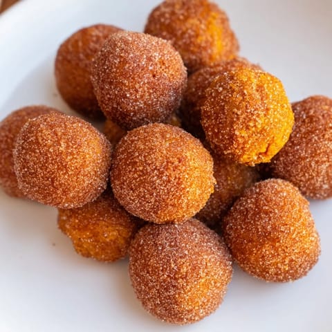 Delicious Pumpkin Muffin Donut Holes coated in warm cinnamon sugar, great for snacks.  