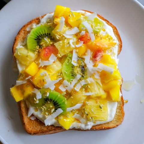 Vibrant yogurt-custard toast featuring mango and pineapple, perfect for brunch gatherings.  