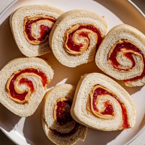 Quartered PB&J pinwheel rolls, a colorful snack with layers of peanut butter and jelly.