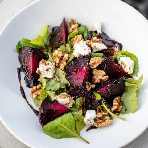 Freshly assembled beet and goat cheese salad, ready to eat, with bright greens and tangy vinaigrette.