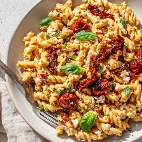 Creamy Baked Feta Pasta 2.0 topped with caramelized onions and colorful cherry tomatoes.  
