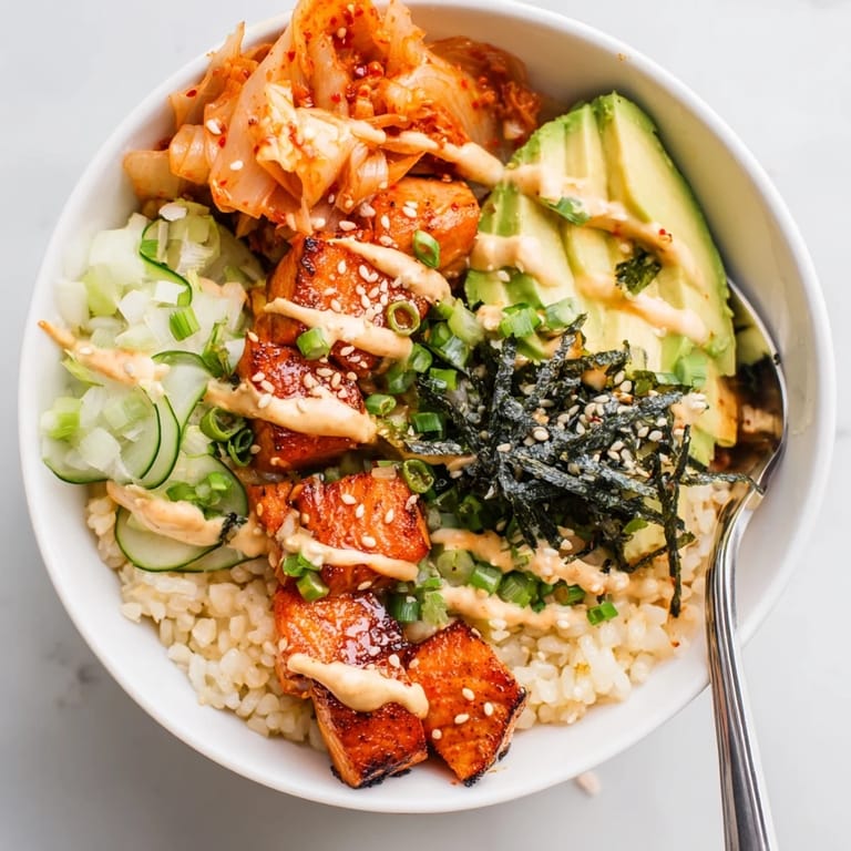 A colorful Crispy Salmon Rice Bowl with golden rice and creamy avocado slices.  