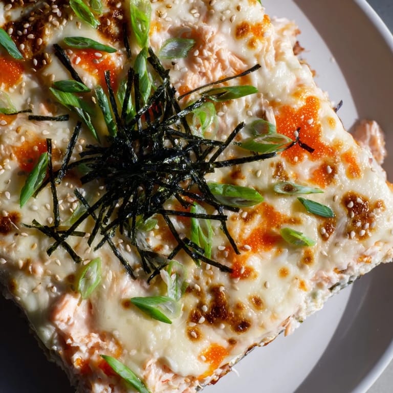 A bubbly, baked Creamy Salmon Sushi Bake, featuring flaky salmon and creamy sauce, perfect for serving.