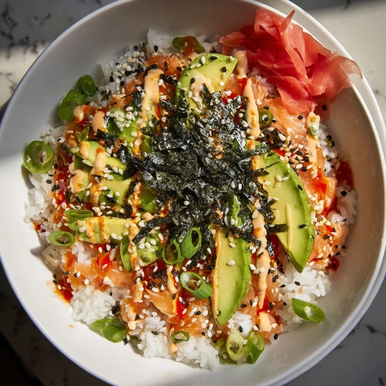 A close-up view of a ready-to-eat Classic Salmon Rice bowl with avocado and nori.
