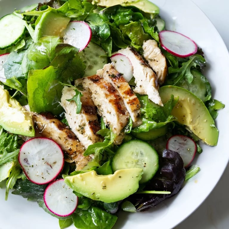 Spring Detox Chicken Salad showcases mixed greens, avocado slices, and juicy grilled chicken tossed in a lemony dressing for a refreshing meal.