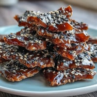 Crunchy black sesame brittle with glossy caramel and toasted seeds, perfect for dessert or snacking.  
