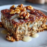 Wholesome high-protein banana bread baked oats with ripe bananas, creamy yogurt, and crunchy walnuts, perfect for a hearty breakfast.
