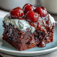 Decadent Cherry Cola Chocolate Poke Cake with creamy frosting and bright cherries.
